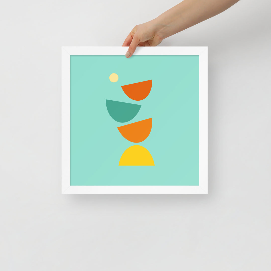 Digital minimalist white framed poster in bright colors with geometric shapes being held in a hand to show size